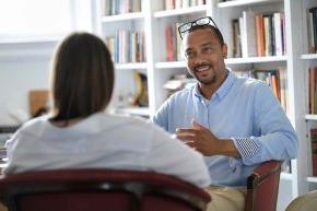 Professor talks with student in office